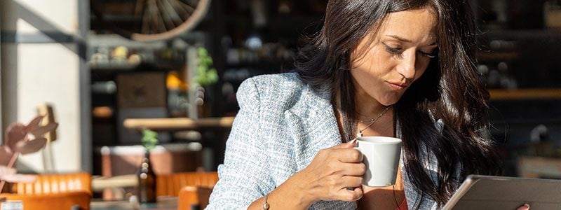 Woman reading news on a tablet in a cafe