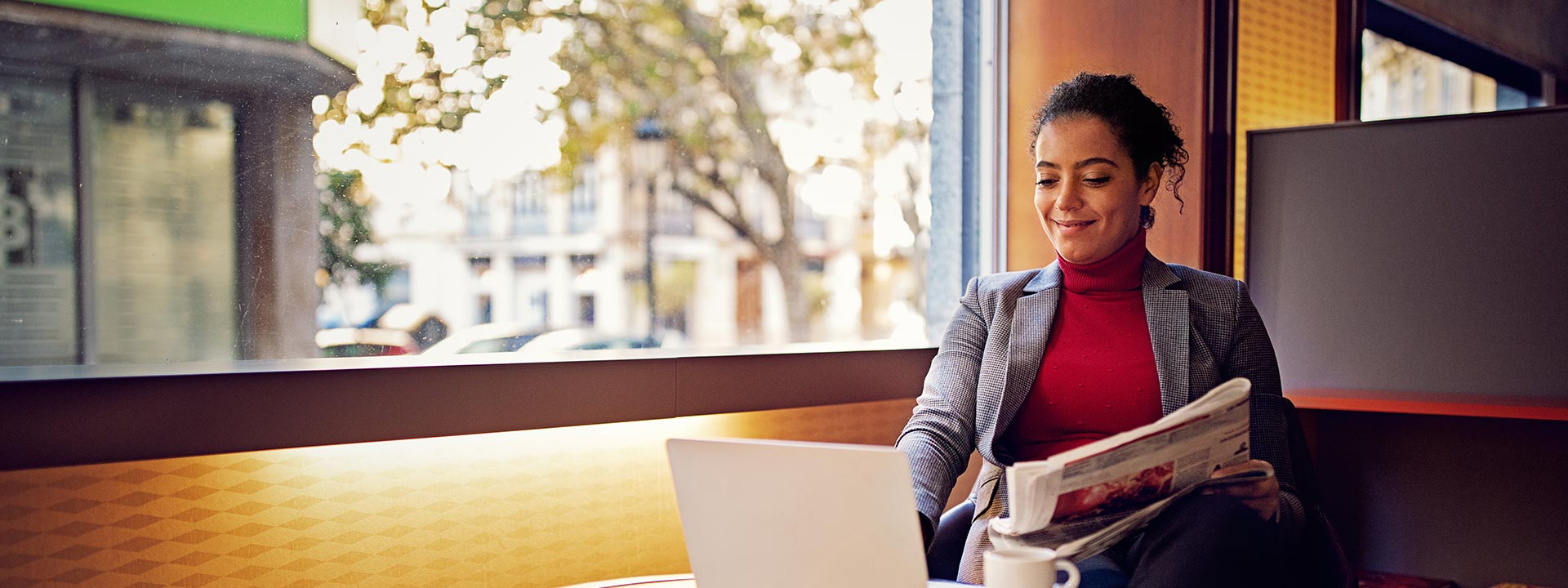 Woman reading news on a tablet in a cafe