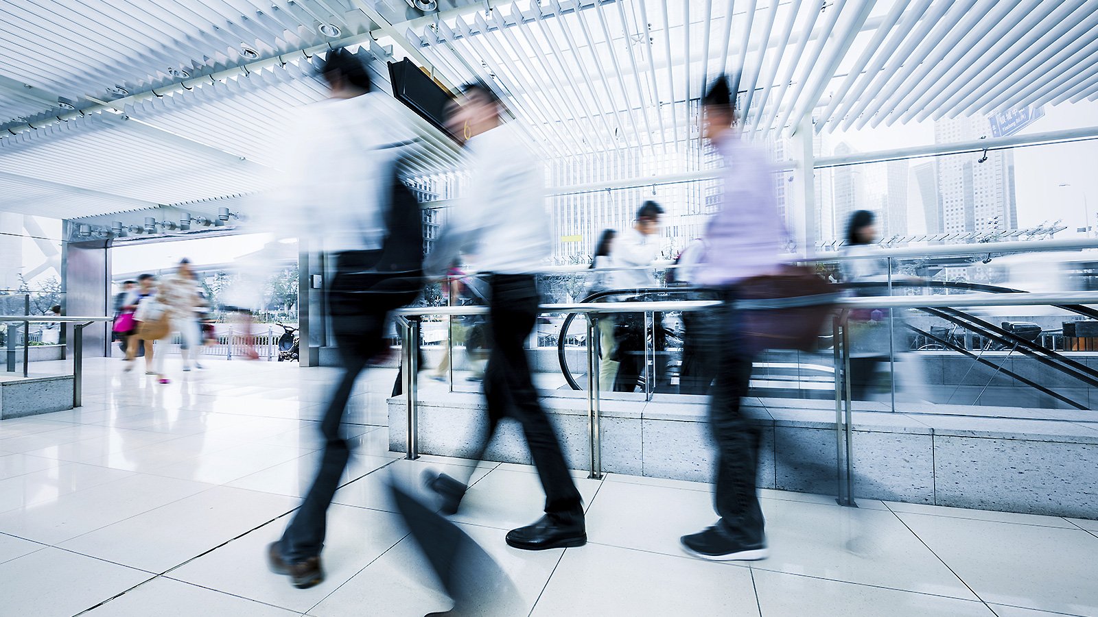 Blurry group of people walking inside a building.