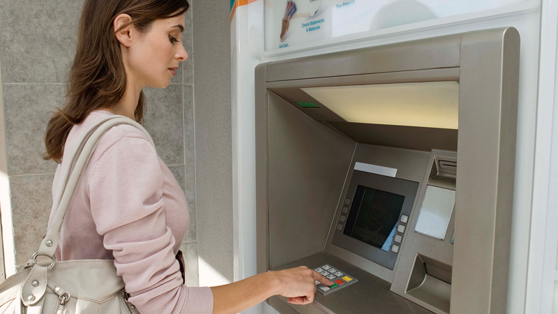 Woman at ATM Woman standing at ATM.