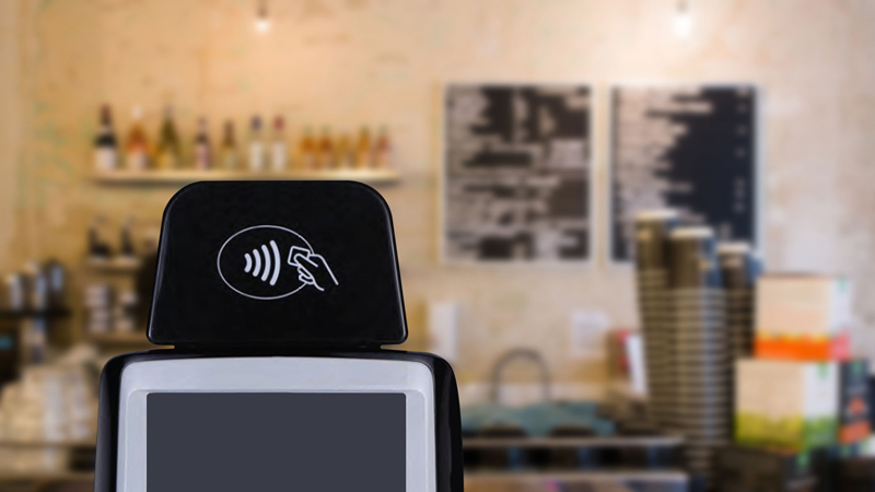 Contactless terminal at a store Closeup of a POS system in a coffee shop displaying the Tap to Pay logo.