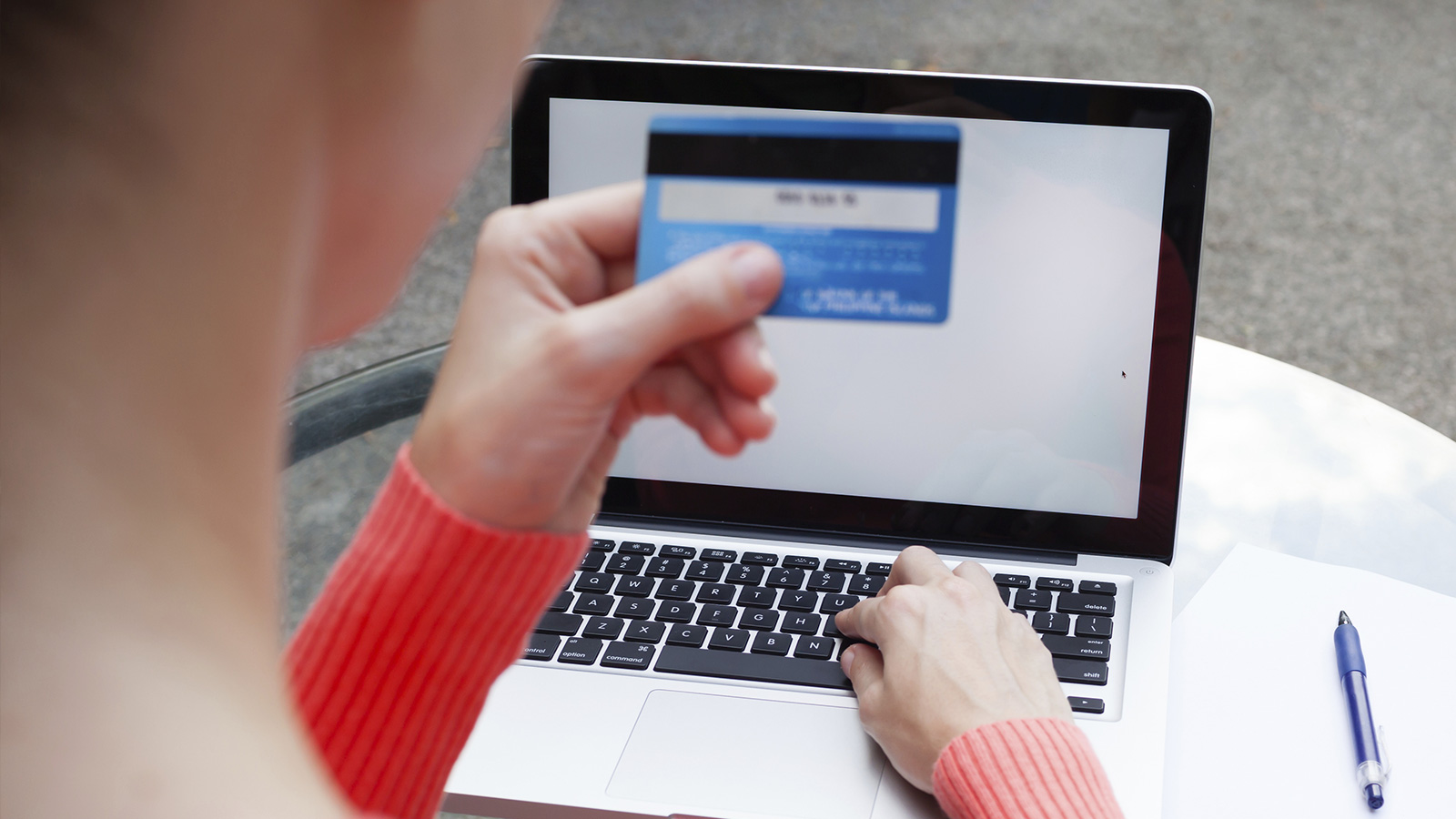 Woman at laptop checking Card Verification Value 2 of Visa card. Woman at laptop checking Card Verification Value 2 of Visa card.