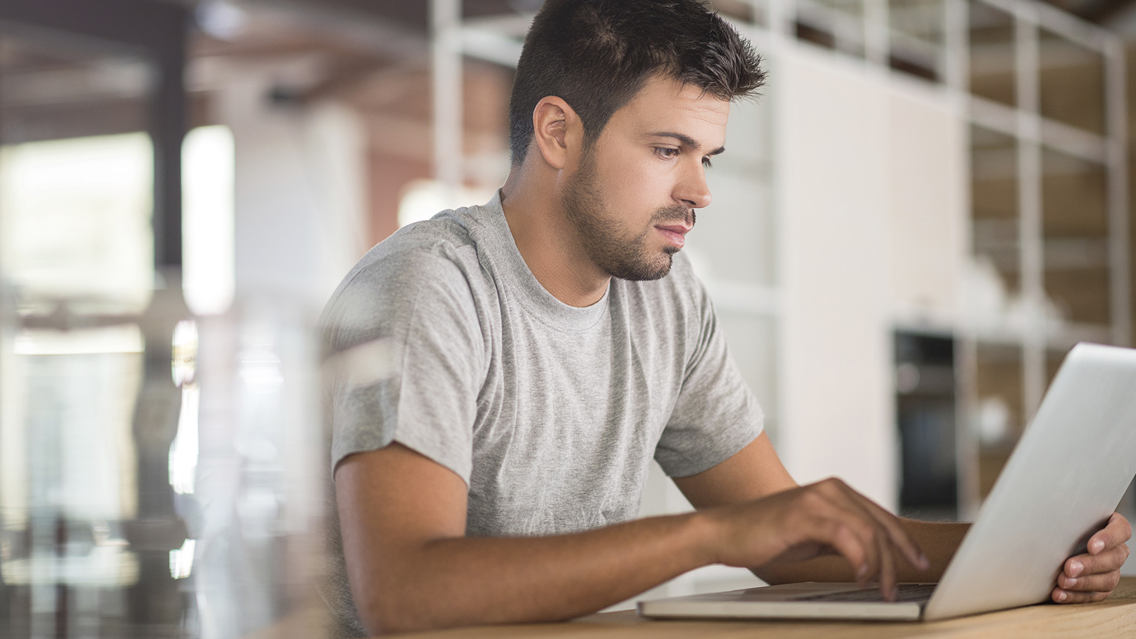 Seated man using laptop at home. Seated man using laptop at home.