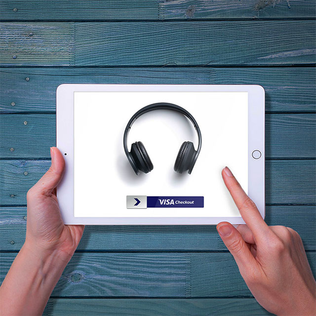 Person shopping for headphones on a tablet using Visa Checkout.