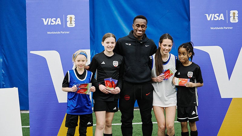 Visa Play and Stay group photo with Visa logo displayed on backdrops.
