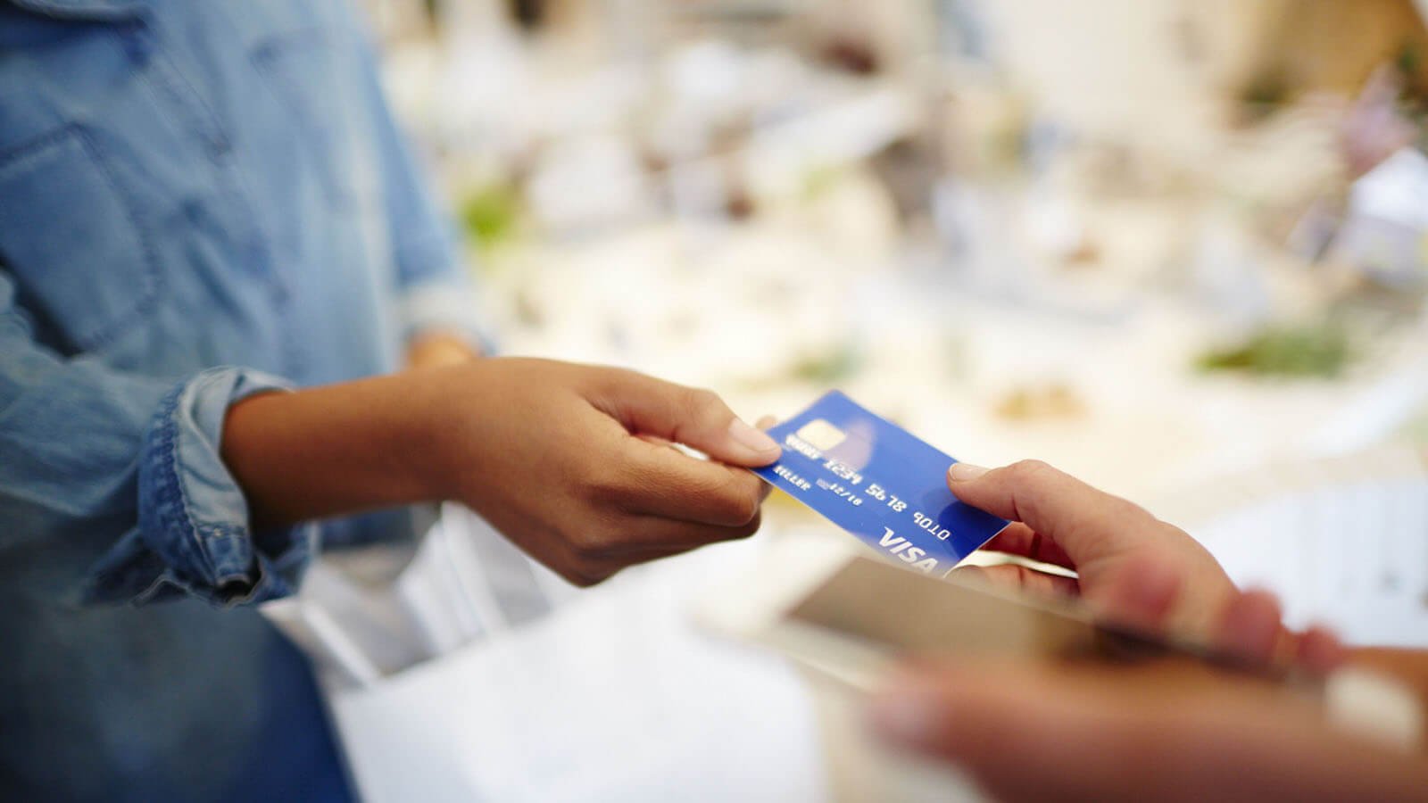 Person handing a Visa card to someone