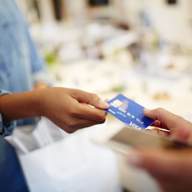 Person handing a Visa card to someone